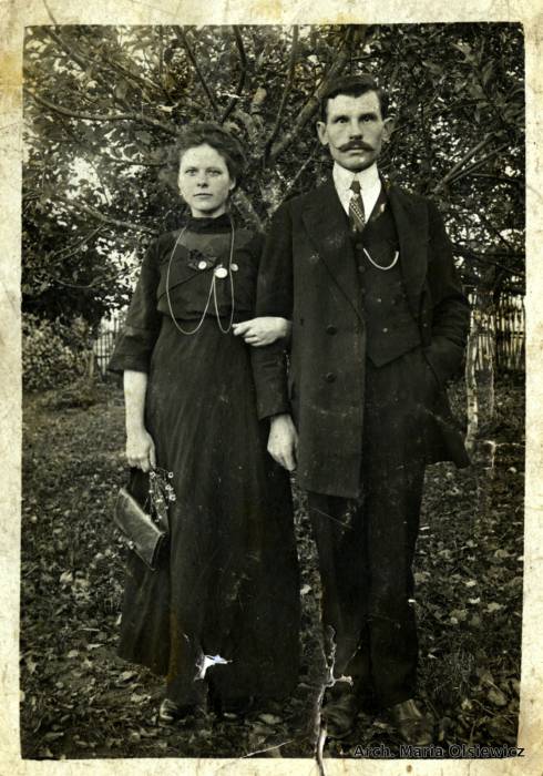 Albina Olsiewicz (z domu Rynkiewicz) i jej mąż Maksymilian Olsiewicz.<br>Zdjęcie wykonane w sadzie w Bartylówce.<br>Albina ma na szyi zegarek który jej skradziono na jakimś targu. Zegarek przywiózł jej Maksymilian z Ameryki (drugi przywiózł sobie).<br>Albina była bardzo piękną kobietą. Mówiono, że jest najładniejsza z dzieci Rynkiewiczów.