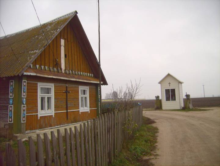 Chata z ozdobnymi zewnętrznymi elementami na początku wioski.
