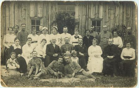 Przed szpitalem w Pińsku (fotografia zrobiona po wrześniu 1915r.) Z lewej strony, siedzi na trawie, dziewczynka, moja Ciocia Helena Nowotna ur. w 1897 r w Pińsku, obejmuje ją jakaś pani z rodziny. Drugi od lewej - to ksiądz Kazimierz Bukraba (w Pińsku od 1912 r., późniejszy biskup piński), oraz dr.Gierchoch z personelem medycznym, podobno zmarł w latach 60-tych w Pińsku, a w Brześciu mieszka Jego Córka. Niestety nie znam wiecej nikogo na tej fotografii. Może ktoś z Pińszczan posiada tę fotografię opisaną.